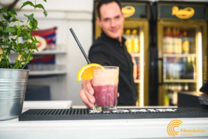 Barkeeper präsentiert seine Cocktail-Kreation am Tresen